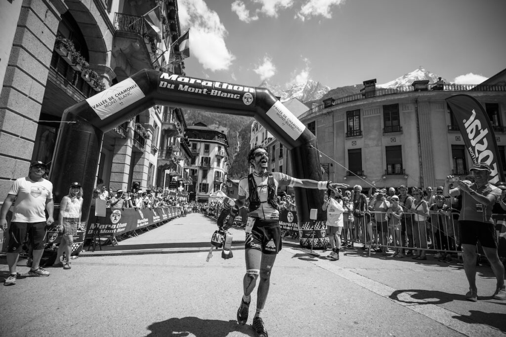Runner celebrates at the finish of UTMB, photo credit Martina Valmassoi