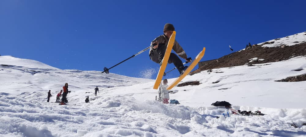 An Afghan boy gets some nice air off a ski jump on homemade wooden skis.