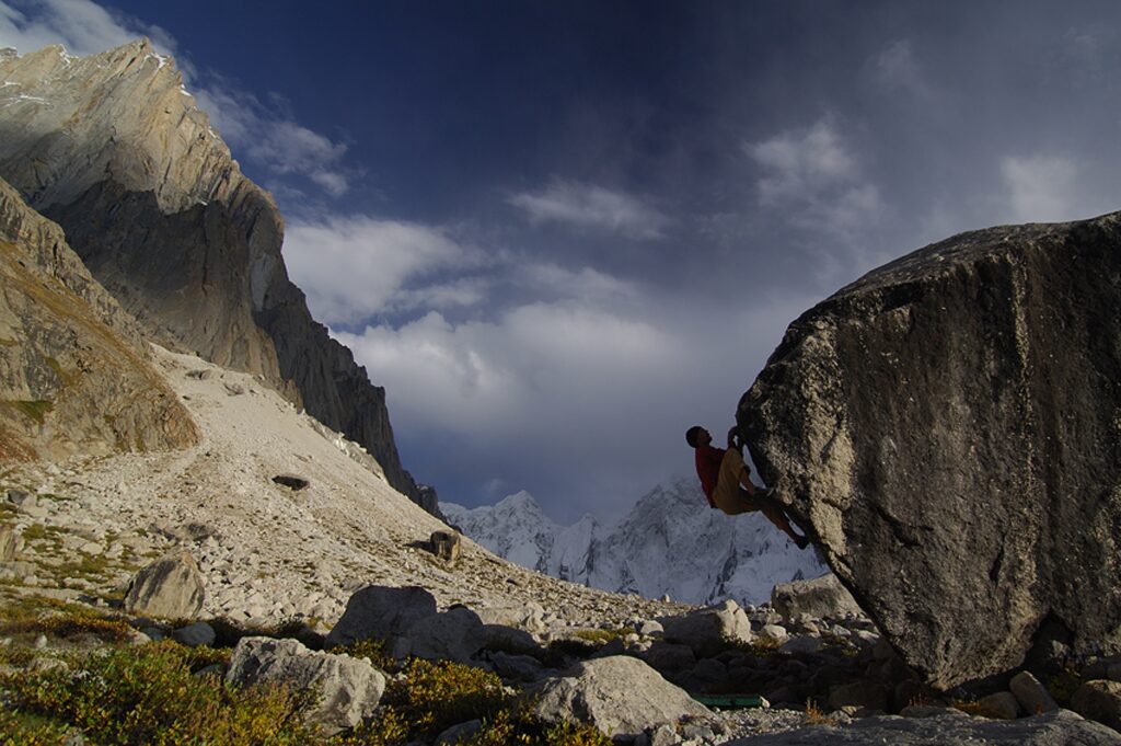 A climber on an overhang on a boulder.