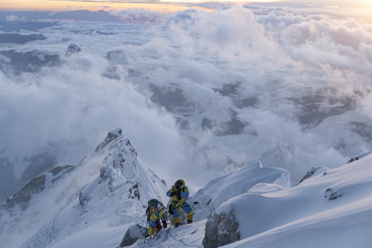 Two mountaineers with a snowy backdrop.