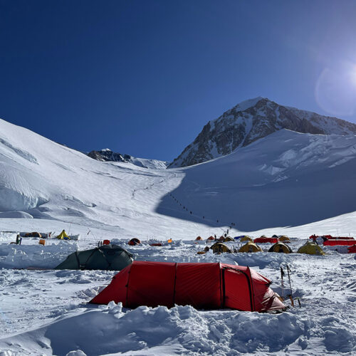 A busy day at Camp 3 at 11,000 feet, with the route winding up Motorcycle Hill visible above.